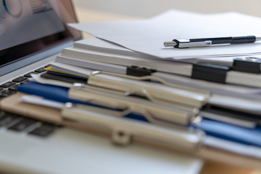 A close-up view of various documents placed on a laptop keyboard.