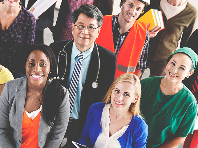 A group of diverse professionals from various fields, including a doctor, construction worker, nurse, and business woman, standing together and smiling.