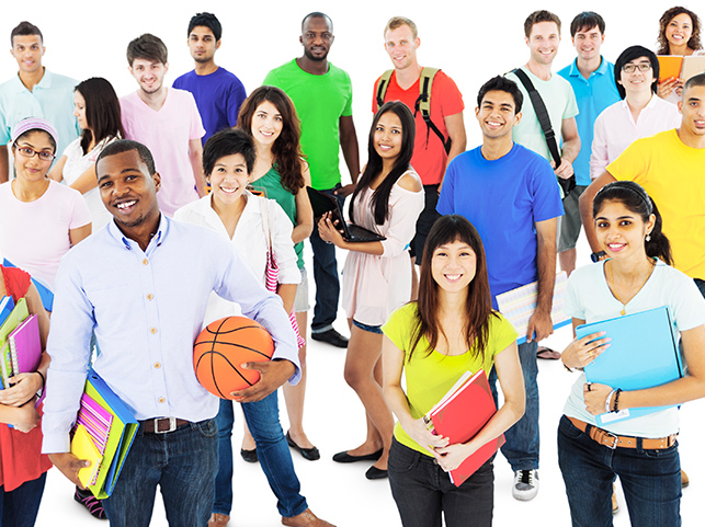 Diverse group of young students holding books and bags, smiling and posing together. The group includes individuals of various ethnicities, all appearing cheerful and united.