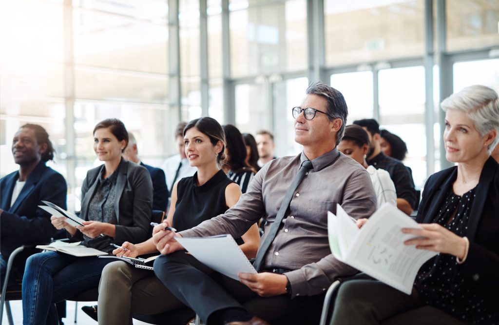 Group of business people sitting in a conference room listening to a lecture.